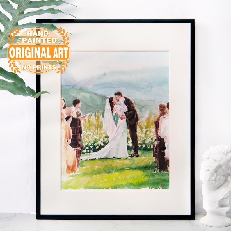 Puede incluir: Pintura acuarela de una ceremonia de boda. La novia y el novio se besan en primer plano, mientras que los invitados est&aacute;n sentados en el fondo. La pintura est&aacute; enmarcada en un marco negro.