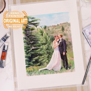 Puede incluir: Una pintura de acuarela de una pareja de bodas de pie en un bosque. La novia lleva un vestido blanco y el novio lleva un traje oscuro. La pintura est&aacute; pintada a mano y firmada por el artista. "Hand Painted Original Art No Prints" est&aacute; escrito en una pancarta dorada en la parte superior de la pintura.