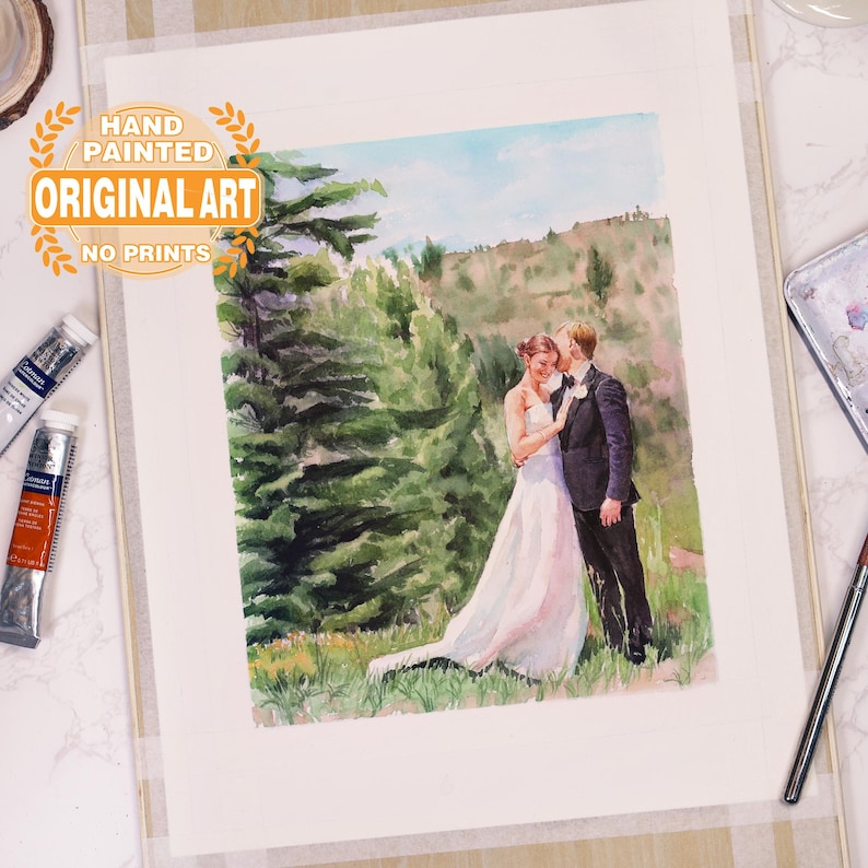 Puede incluir: Una pintura de acuarela de una pareja de bodas de pie en un bosque. La novia lleva un vestido blanco y el novio lleva un traje oscuro. La pintura est&aacute; pintada a mano y firmada por el artista. "Hand Painted Original Art No Prints" est&aacute; escrito en una pancarta dorada en la parte superior de la pintura.