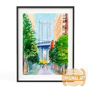 May include: Framed watercolor painting of the Manhattan Bridge in New York City. The artwork features a blue bridge, buildings, and green trees lining a street. The painting is in a black frame and includes text that reads "Hand Painted Original Art No Prints."