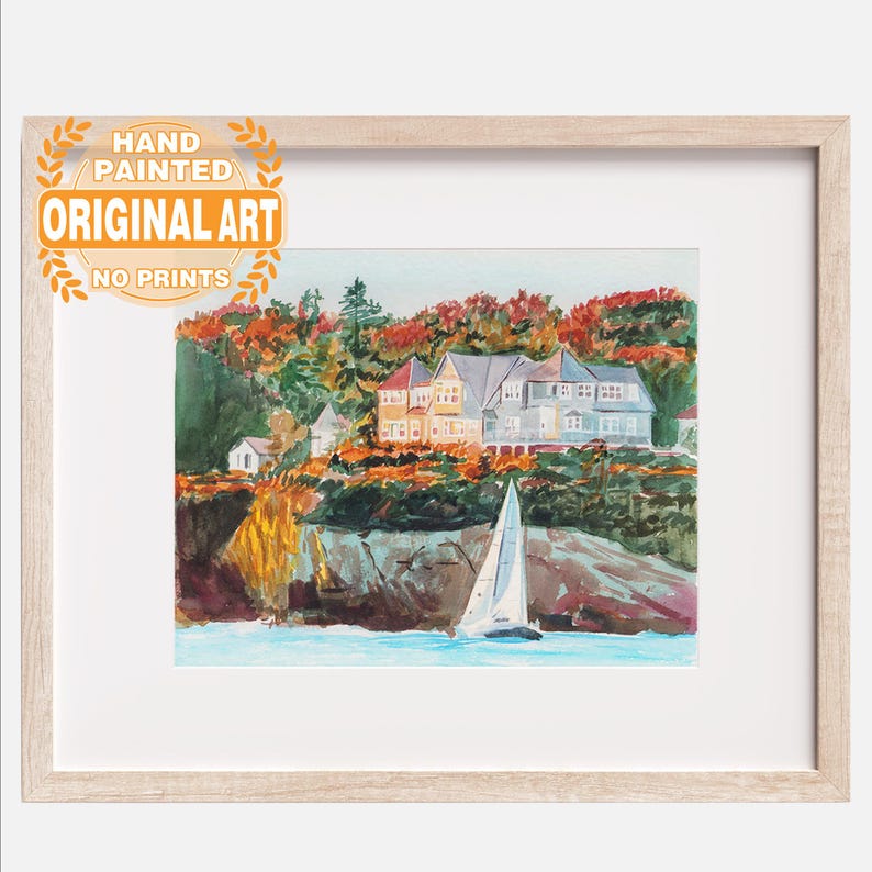 May include: Hand-painted original art print of a coastal scene. The watercolor painting depicts houses on a cliff overlooking the water, with a sailboat in the foreground. The artwork is framed in a light wood frame. The text on the image says "Hand Painted Original Art No Prints".