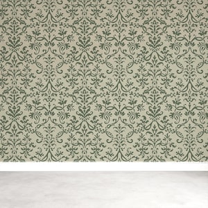 a wall with a repeating pattern of green and brown floral designs, creating a decorative and ornate appearance.