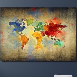 May include: A colourful world map painting on a canvas with a textured background. The map is painted in shades of blue, green, yellow, orange, and red. The painting is hanging on a grey wall above a light blue sofa.