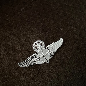 以下が含まれることがあります： 中央にプロペラと星が付いた銀色の空軍パイロットの翼バッジ