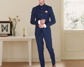 Puede incluir: Un traje azul marino con cuello mandarín, botones de madera y un pañuelo a juego. El traje incluye una chaqueta y pantalones a medida. La persona lleva zapatos de cuero marrón. El traje es un conjunto de vestir formal.
