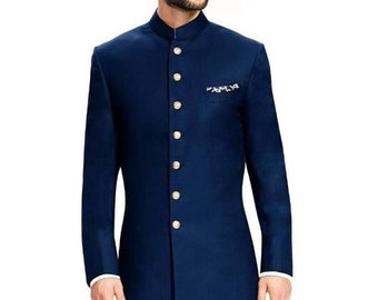 May include: A navy blue long-sleeved kurta with a mandarin collar and gold buttons. The kurta has a white pocket square with an embroidered design. The model is wearing white pants and navy blue velvet loafers.