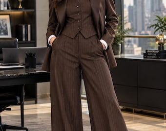 May include: A dark brown pinstriped three-piece suit consisting of a tailored blazer, a button-up vest, and wide-leg trousers. The ensemble is paired with a crisp white collared shirt and a matching brown necktie, creating a formal professional look.