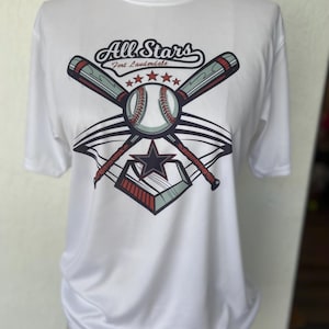 May include: White t-shirt with a baseball-themed graphic. The graphic features two crossed bats, a baseball, a star, and the text "All Stars Fort Lauderdale".