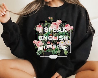 May include: Black sweatshirt with a floral design and the text "I speak English but I love in Spanish".