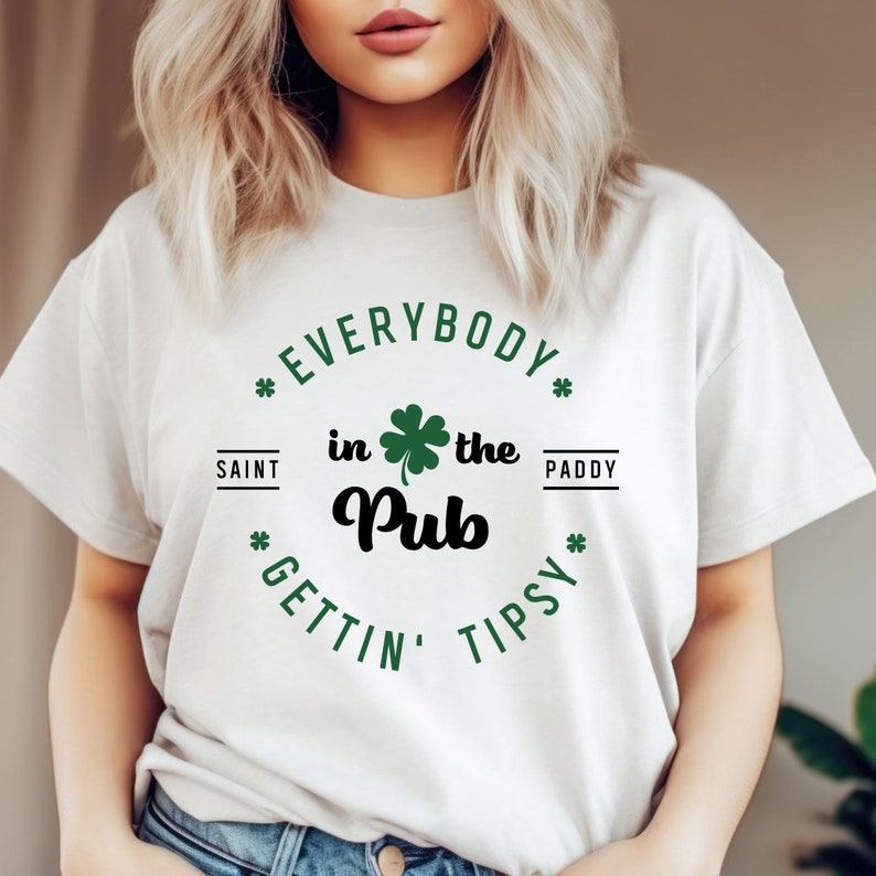 Puede incluir: Camiseta blanca con un tr&eacute;bol verde y el texto "Everybody in the Pub Gettin' Tipsy" en un c&iacute;rculo.