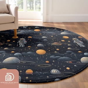 May include: A round rug with a space-themed design. The rug features a dark blue background with illustrations of planets, stars, and astronauts. The planets are in shades of orange, gray, and yellow. The rug is placed on a wooden floor.