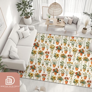 May include: A rectangular rug with a floral pattern of potted sunflowers and other flowers in orange, yellow and red. The rug has a cream background and is surrounded by white furniture and plants.