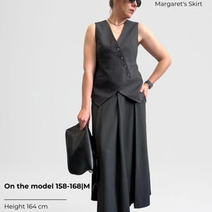 May include: A woman wearing a black and white striped vest and a long black skirt. The text "Create an outfit" is at the top of the image. The text "Victoria's Jacket" and "Margaret's Skirt" are below the text "Create an outfit".