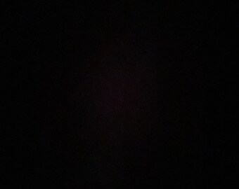 May include: A black background with a slight purple hue in the center.