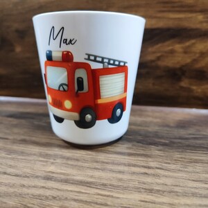 May include: White ceramic cup with a red fire truck illustration and the name "Max" printed on the front.