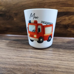 May include: White personalized cup with a red fire truck illustration and the name "Max" printed on the front.