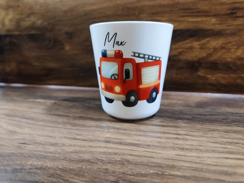 May include: White personalized cup with a red fire truck illustration and the name "Max" printed on the front.