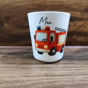 May include: White personalized cup with a red fire truck illustration and the name "Max" printed on the front.