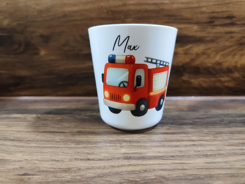 May include: White personalized cup with a red fire truck illustration and the name "Max" printed on the front.