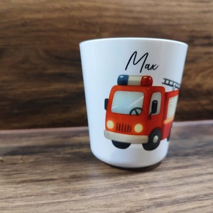 May include: White ceramic cup with a red fire truck illustration and the name "Max" printed on the front.