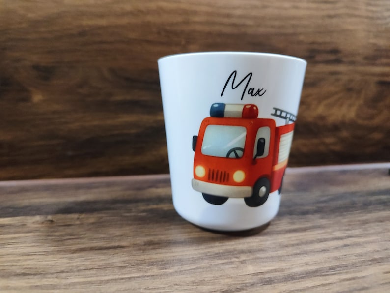 May include: White ceramic cup with a red fire truck illustration and the name "Max" printed on the front.