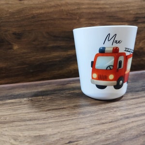 May include: White personalized cup with a red fire truck illustration and the name "Max" printed on the front.