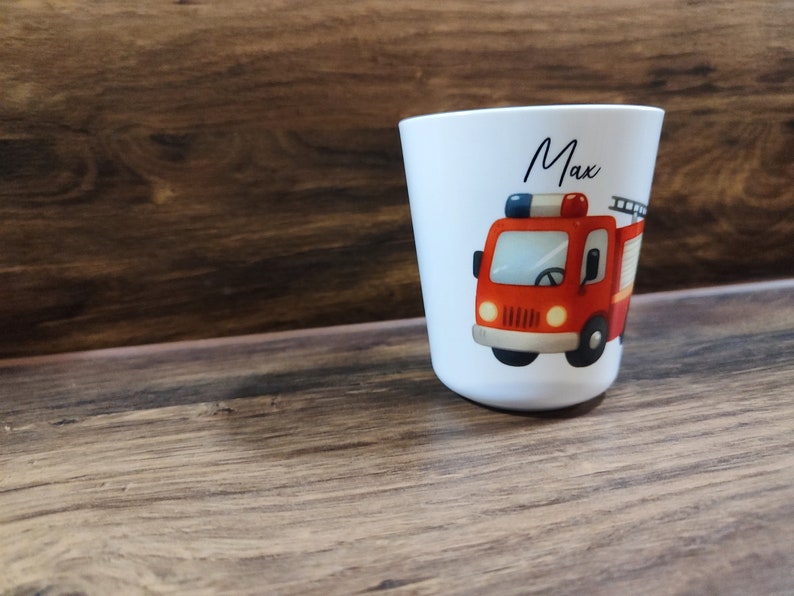 May include: White personalized cup with a red fire truck illustration and the name "Max" printed on the front.