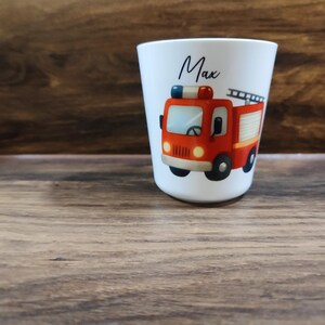 May include: White personalized cup with a red fire truck illustration and the name "Max" printed on the front.