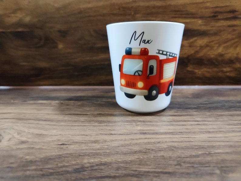 May include: White personalized cup with a red fire truck illustration and the name "Max" printed on the front.