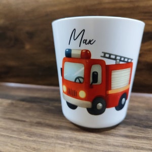 May include: White ceramic cup with a red fire truck illustration and the name "Max" written in black cursive.