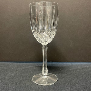 May include: A clear glass wine glass with a cut crystal design. The glass has a tall stem and a wide bowl.