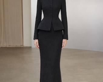 May include: A dark charcoal gray two-piece set consisting of a long-sleeved jacket with a high mandarin collar, a row of matching buttons, and a flared peplum waist, paired with a matching floor-length, straight-cut skirt and black pointed heels.