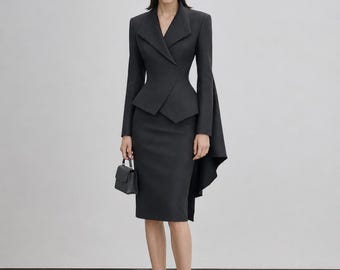 May include: A dark gray tailored blazer with a sharp lapel, fitted waist, and long flowing back panels, paired with a matching knee-length pencil skirt, black pointed-toe high heels, and a small structured black handbag with a top handle.