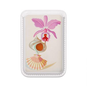 May include: A rectangular white card holder featuring a printed illustration of a pink orchid flower positioned above a spiraled white seashell and a fan-shaped pink and white scallop shell against a light cream-colored background.