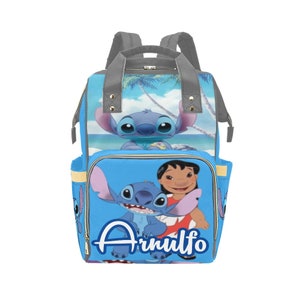 May include: Blue and grey backpack with a cartoon image of Stitch and Angel from Lilo & Stitch. The backpack has a large pocket on the front with the name "Arnulfo" written in white.