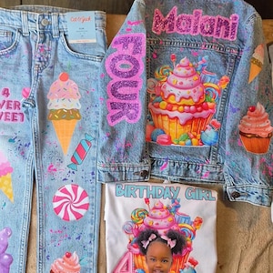 Puede incluir: Un conjunto de chaqueta y vaqueros de mezclilla, junto con una camiseta blanca, todos decorados con diseños coloridos y caprichosos. La chaqueta y los vaqueros presentan conos de helado, cupcakes y caramelos. La camiseta tiene una foto y el texto "BIRTHAY GIRL".