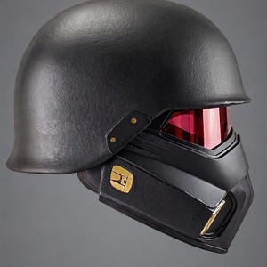 May include: A matte black tactical helmet featuring a smooth rounded dome, a lower face mask section, and a reflective red visor. The side of the mask displays a gold emblem, and the text OBSIDIAN cosplay.com is printed at the bottom center.