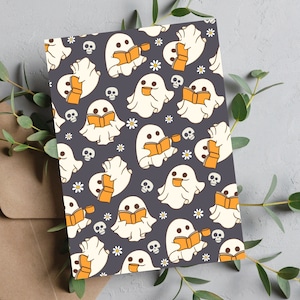 Könnte beinhalten: Ein sich wiederholendes Muster aus weißen Geistern, die auf einem dunkelvioletten Hintergrund Bücher lesen. Die Geister sind schwarz umrandet und haben kleine, schwarze Augen. Die Bücher sind orange mit weißen Seiten. Außerdem sind kleine weiße Blumen und schwarze Schädel über das gesamte Muster verteilt.