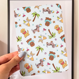 May include: A light blue patterned card featuring cartoon dogs with beach accessories. The dogs are depicted with sunglasses, beach balls, and watermelon slices. Palm trees and starfish are also included in the design.