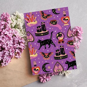 Puede incluir: Fondo morado con un patrón repetido de gatos negros, cristales, lunas, velas y otros símbolos místicos. El patrón es de estilo vintage con un contorno negro y acentos coloridos.