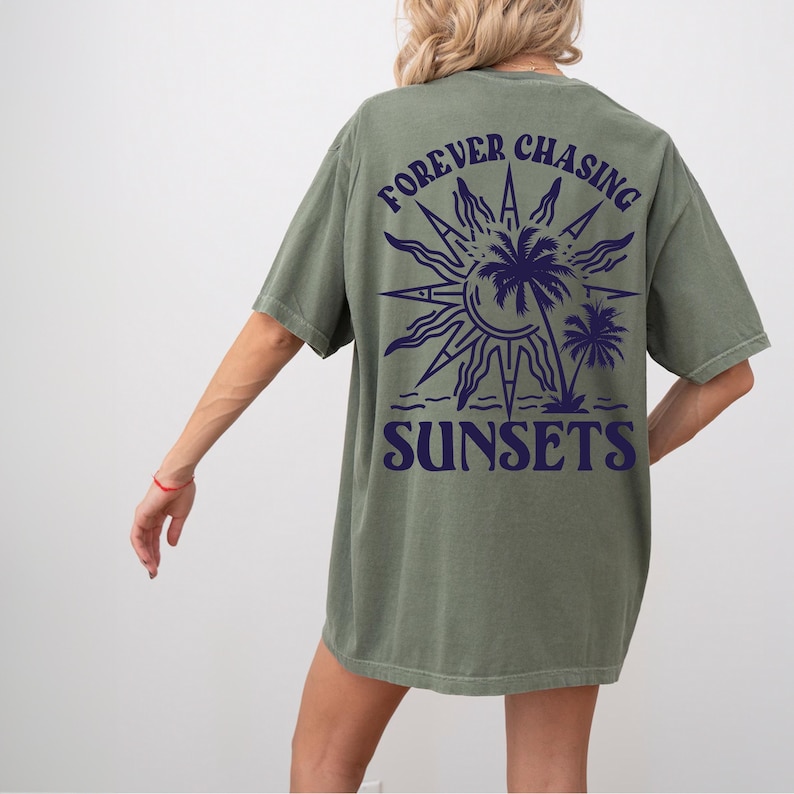 Puede incluir: Una camiseta verde con un gr&aacute;fico en la espalda que dice "FOREVER CHASING SUNSETS" con un sol y palmeras.