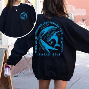 May include: Black sweatshirt with a blue whale graphic and the text "When you go through deep waters, I will be with you. Isaiah 43:2" on the back.