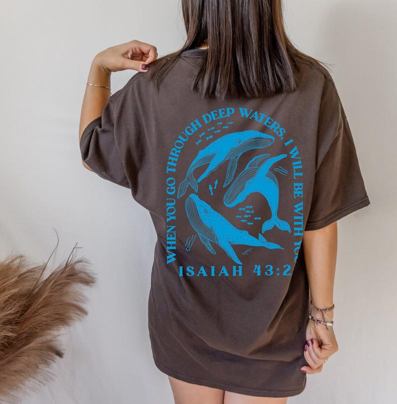May include: Brown t-shirt with a blue graphic of whales and the text "When you go through deep waters, I will be with you" and "Isaiah 43:2".