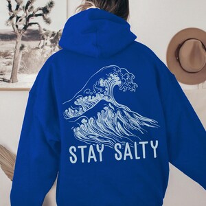 May include: A royal blue hoodie with a white graphic of a large wave and the text "STAY SALTY".