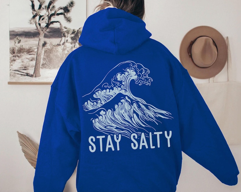 May include: A royal blue hoodie with a white graphic of a large wave and the text "STAY SALTY".