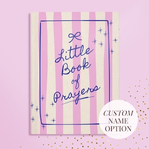 Könnte beinhalten: Ein kleines Buch mit einem Einband mit vertikalen rosa und cremefarbenen Streifen. Der Titel des Buches, "Little Book of Prayers", ist in blauer Schrift innerhalb eines blauen rechteckigen Rahmens geschrieben. Dekorative blaue Sternschnuppen und ein Aufkleber "Custom Name Option" sind ebenfalls sichtbar.