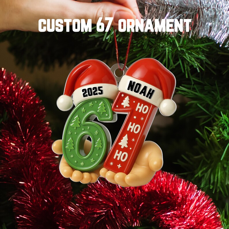 May include: A festive Christmas ornament in the shape of the numbers 6 and 7, with Santa hats. The number 6 is green with Christmas tree designs, and the number 7 is red with the name "Noah" and "Ho Ho Ho". The text "CUSTOM 67 ORNAMENT" is at the top.