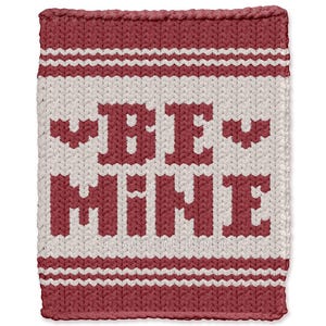 May include: A knitted square in shades of red and cream, featuring the words "BE MINE" in bold, block letters. The design includes horizontal stripes and a textured appearance, perfect for Valentine's Day or a romantic gift.