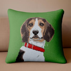May include: A green square throw pillow featuring a pixelated image of a beagle dog. The dog has brown and white fur, with a red collar. The background is a solid green color.