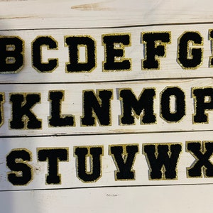 Schwarze Buchstaben mit Goldrand - Preppy schwarze Chenille Patches - selbstklebend und zum Aufbügeln. 5,5 cm. Super für Dein DIY Projekt!